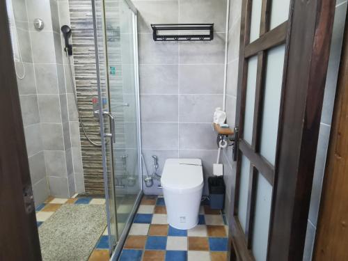 a bathroom with a toilet and a shower at Yangshuo Shui Mo Ju courtyard in Yangshuo
