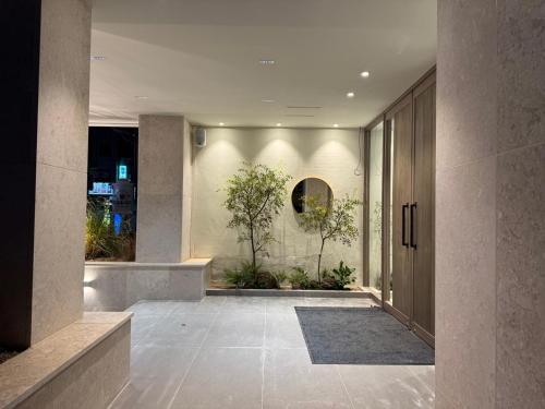 a hallway of a building with a door and plants at Hotel Ami in Gwangju