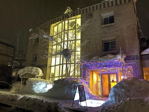 a building with a lit up facade in the snow at Blue Star Hotel in Chikuni