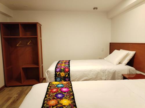 a hotel room with two beds and a closet at Kantu hotel in Cusco