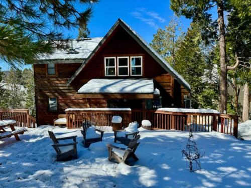 a log cabin with snow in front of it at Hot Tub-EV-AC-Kid Friendly-Arcade Game-Lake Access in Lake Arrowhead