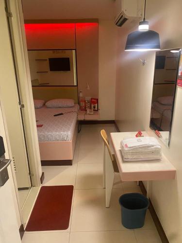 BacoorにあるHotel Sogo Bacoorのベッドとテーブルが備わる小さな客室です。