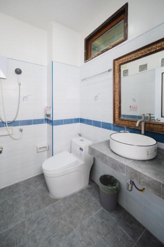 a bathroom with a toilet and a sink and a mirror at C4 Resort in Koh Tao