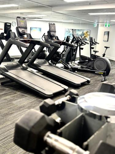 a gym with several tread machines in a room at Crowne Plaza Surfers Paradise by IHG in Gold Coast