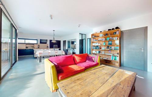 un salon avec un canapé rouge et une table en bois dans l'établissement Awesome Home In Médis, à Médis