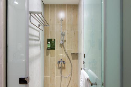 a bathroom with a shower with a glass door at CHECK inn New Taipei LuZhou in Taipei