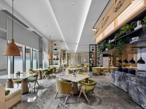 a restaurant with tables and chairs and a bar at Hilton Shanghai Hongqiao International Airport in Shanghai