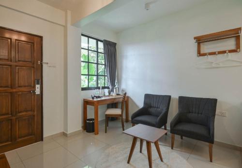 a living room with two chairs and a table at Cameron Highland Retreat in Tanah Rata