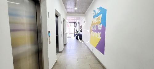 a hallway with white walls and a hallway with purple and yellow signs at Departamentos Exclusivos con wifi, Cocina, TV Smart, toallas, Cowork, Central. San Martin 2406. in Antofagasta