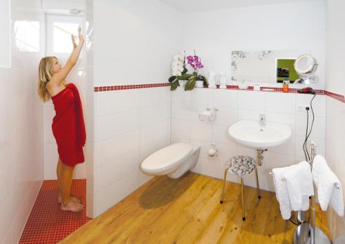 a woman is standing in a bathroom with a sink at Wein-Träume in Thüngersheim