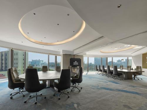 a conference room with a table and chairs and windows at Hilton Shanghai Hongqiao International Airport in Shanghai