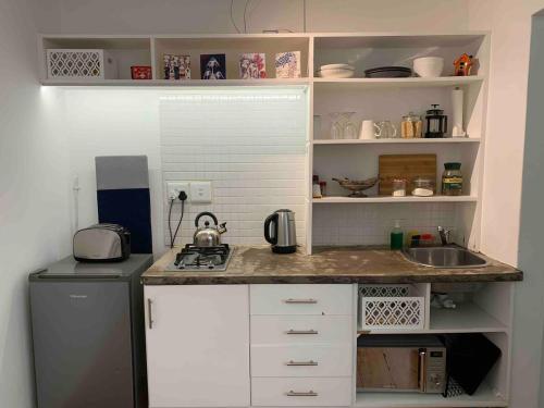 a small kitchen with a counter and a sink at Satu's Inn-Bloem - Ferienwohnung in Bloemfontein