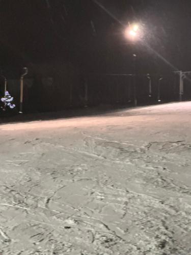a snow covered street at night with a street light at Wichrowe Wzgórze 4 in Rajcza