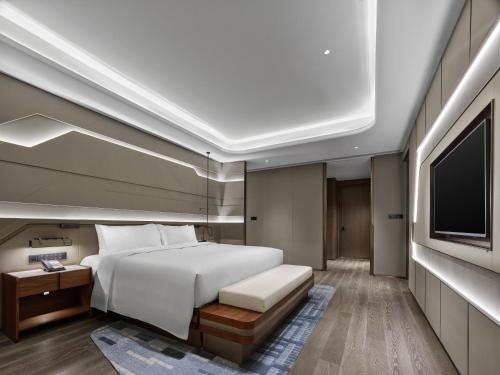 a bedroom with a bed and a flat screen tv at Hilton Shanghai Hongqiao International Airport in Shanghai