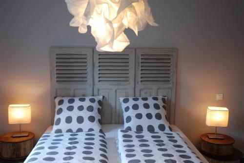a bedroom with two twin beds and two lamps at L’Été en Novembre in Kirrwiller