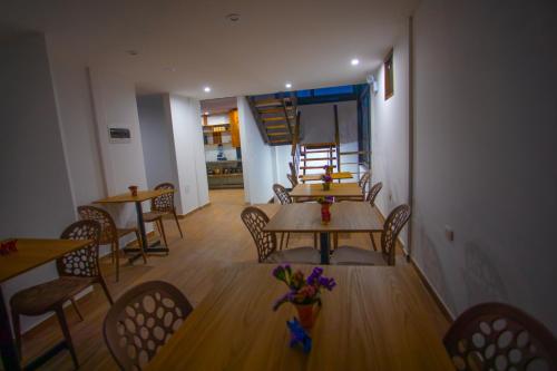 a dining room with tables and chairs and a staircase at MUJU hotel by Ämak in Urubamba