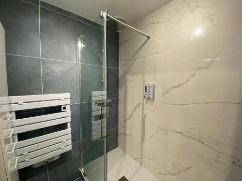 une salle de bain avec une douche avec une porte vitrée dans l'établissement Appartement rénové face plage, max 4 pers, terrasse - FR-1-709-81, à Fouras