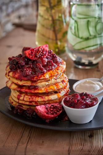 einen Stapel Pfannkuchen auf einem Teller auf einem Tisch in der Unterkunft Kwandwe Private Game Reserve - Melton Manor in Grahamstown
