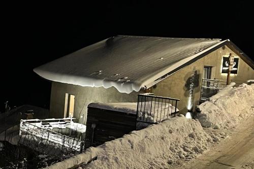 une petite maison couverte de neige la nuit dans l'établissement Le Repère des Cerfs - access to Val Thorens, à Orelle