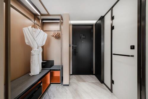 a dressing room with a robe hanging on a closet at Atour S Hotel Chengdu Taikoo Li in Chengdu