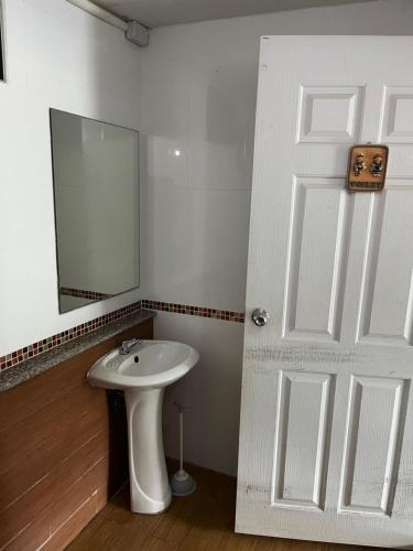 a white bathroom with a sink and a mirror at บ้านสวนรัญจวนสาขาสุราษฎร์ธานี in Ban Huai Chiat