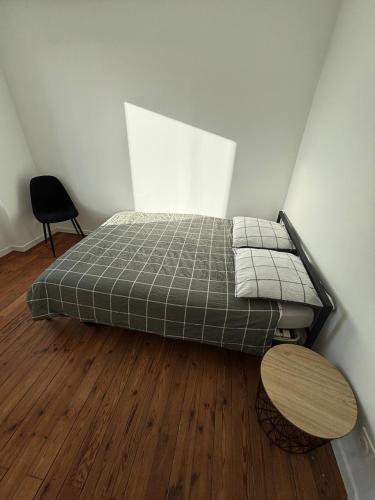 una camera da letto con un letto e un pavimento in legno di Maison de ville - Chez Marsou a Poitiers