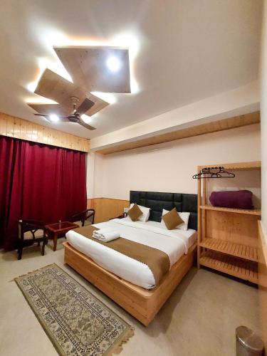 a bedroom with a large bed and a red curtain at Hotel Cloud Height in Dharmsala