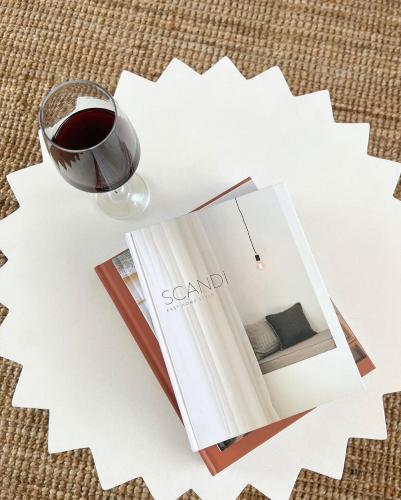 a book and a glass of wine on a table at Dreamy Staiz - Riverland Abode in Barmera