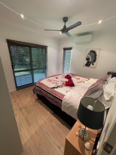 a bedroom with a bed with a teddy bear on it at Tropical family beach house in Holloways Beach