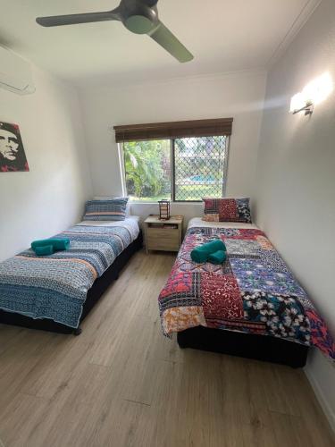 a bedroom with two beds and a window at Tropical family beach house in Holloways Beach
