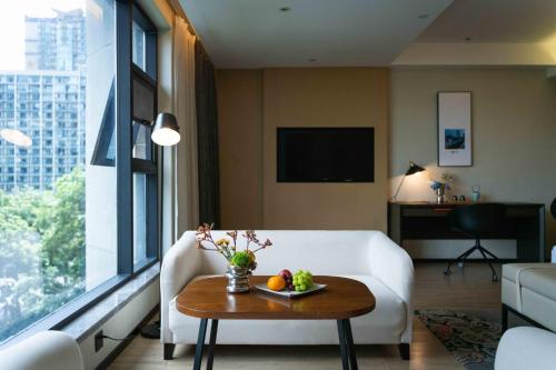 a living room with a white couch and a table at Atour S Hotel Chengdu Taikoo Li in Chengdu