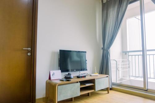a living room with a flat screen tv on a table at Cozy Stay 1BR at M-Town Signature Apartment By Travelio in Tangerang