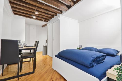 - une chambre avec un lit doté d'oreillers bleus et d'une table dans l'établissement Studio Charmant Appartement Quartier Les Marais Free Netflix, à Paris