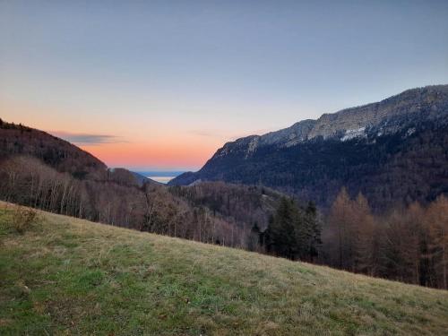 una colina de hierba con una puesta de sol en las montañas en AirBee&Bee - Creux du Van, en Brot-Dessous