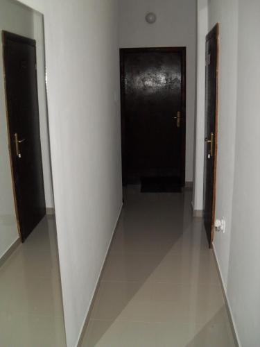 a hallway with two black doors and a white wall at Apartments Colic in Herceg-Novi