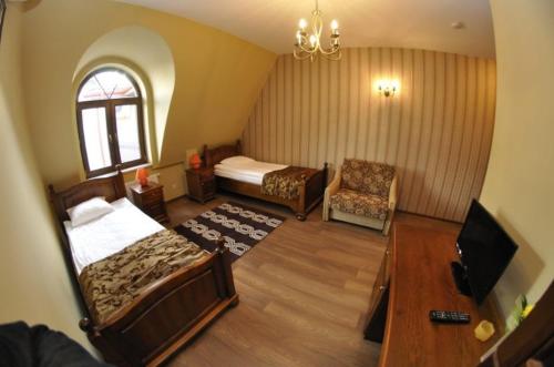 a bedroom with a bed and a tv and a chair at Kryształowy Pałacyk in Kozienice