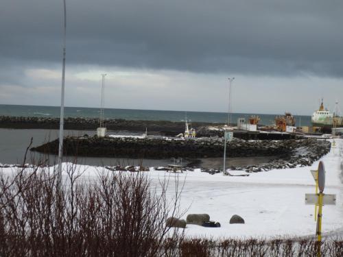 a harbor with a pier and snow on the ground at Teigur Guesthouse in Akranes