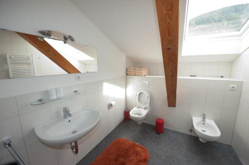 a white bathroom with a sink and a toilet at Appartements Margit in Vipiteno