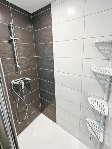 La salle de bains est pourvue d'une douche avec du carrelage noir et blanc. dans l'établissement Chalet les Estives au pied des pistes, le lioran, terrasse, 2 chambres, 4 lits, à Laveissière