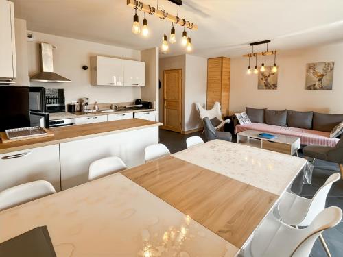 a kitchen and living room with a table and chairs at Chalet les Estives au pied des pistes, le lioran, terrasse, 2 chambres, 4 lits in Laveissière