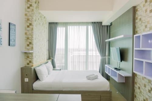 a hotel room with a bed and a window at Cozy Living Studio Apartment Tree Park City BSD By Travelio in Tangerang