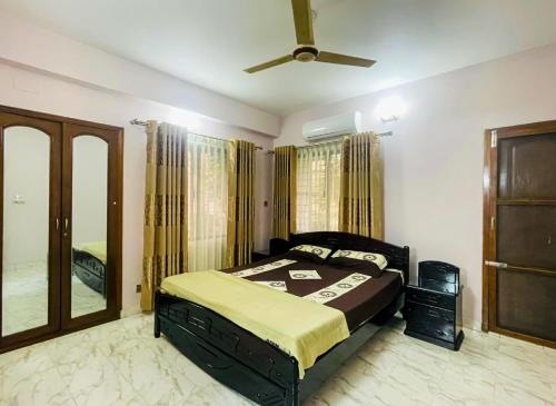 a bedroom with a bed and a ceiling fan at Uttara Luxury Apartment Near Airport & Metro in Dhaka