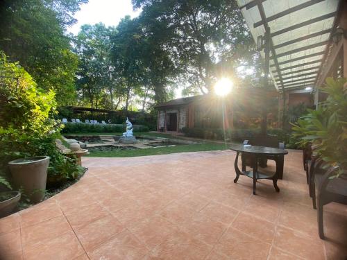a patio with a table and a bench in a yard at The Journey House Lifestyle Boutique Hotel in Kanchanaburi