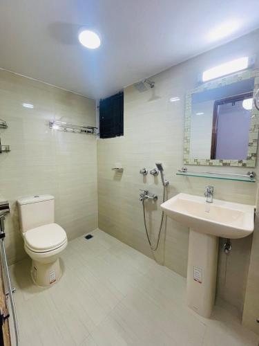 a bathroom with a toilet and a sink at Uttara Luxury Apartment Near Airport & Metro in Dhaka