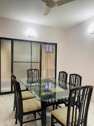 a dining room with a glass table and chairs at Uttara Luxury Apartment Near Airport & Metro in Dhaka