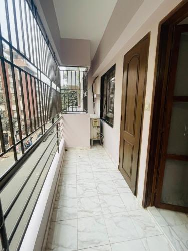 an empty hallway with windows and a door at Uttara Luxury Apartment Near Airport & Metro in Dhaka