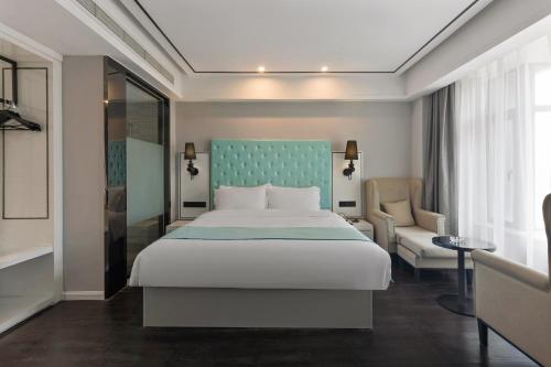 Un dormitorio con una cama grande y una silla. en 如家睿柏云酒店建设路东郊记忆店, en Chengdú