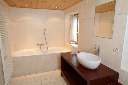 ein Badezimmer mit einer Badewanne, einem Waschbecken und einer Badewanne in der Unterkunft Chalet Diana in Le Sépey