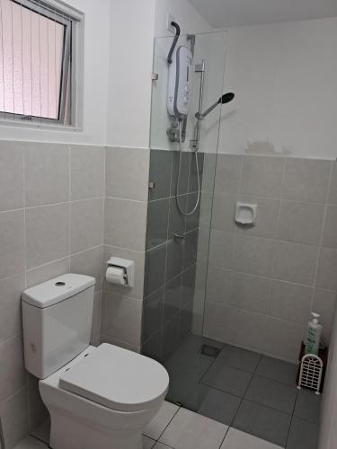 a bathroom with a shower with a toilet and a phone at Aurora's Place at Alanis Residence in Sepang