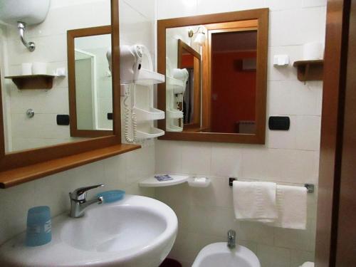 uma casa de banho com um lavatório, um espelho e um WC. em Hotel Rosso Di Sera em Pietramelara